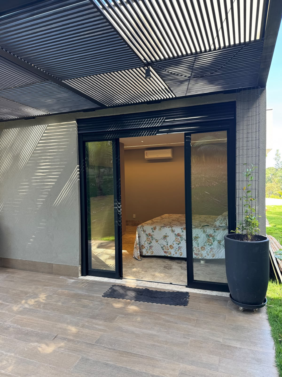 Dormitório com esquadria preta e cobertura metálica linear