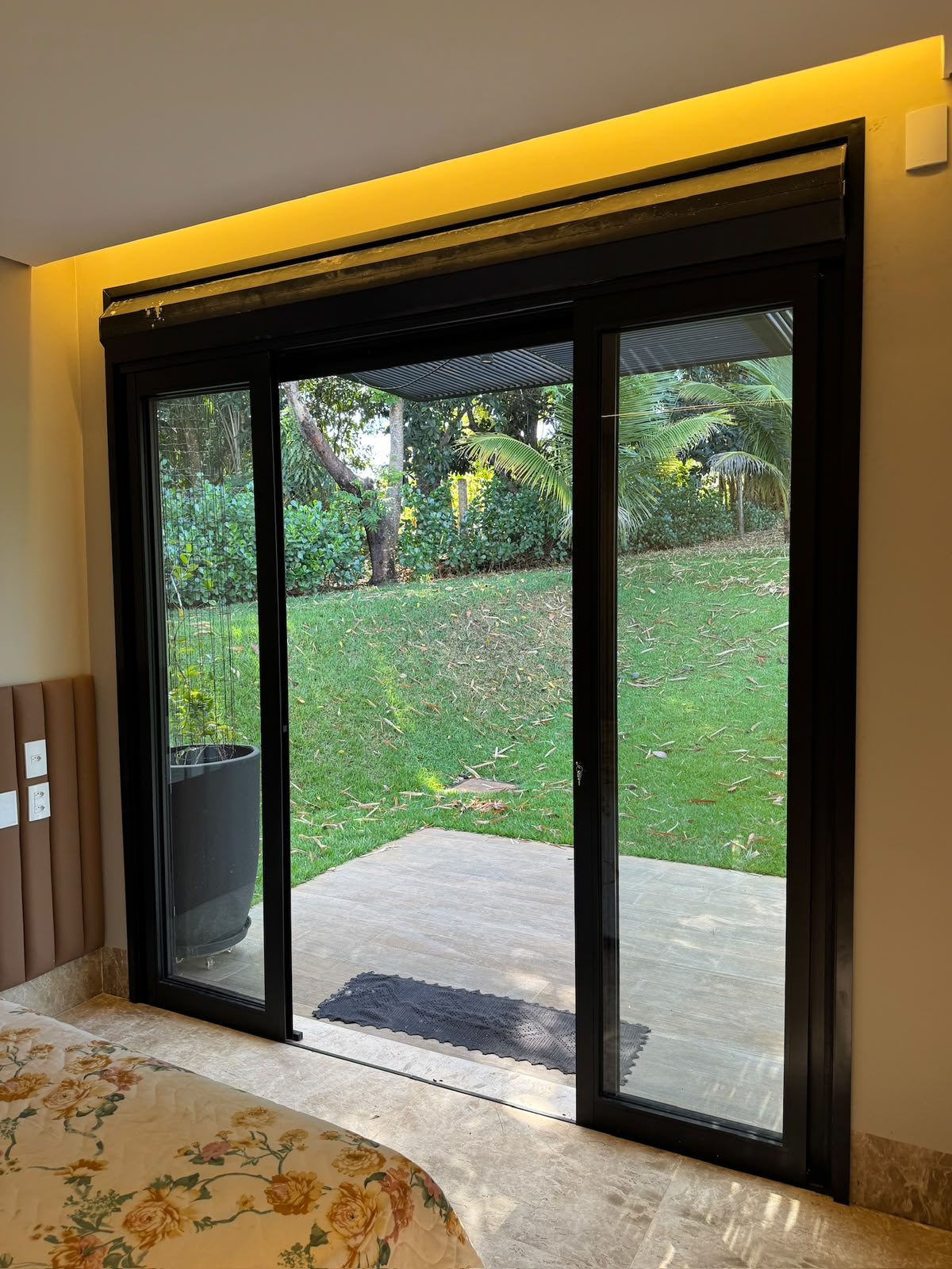 Porta de correr em alumínio preto com abertura para o jardim